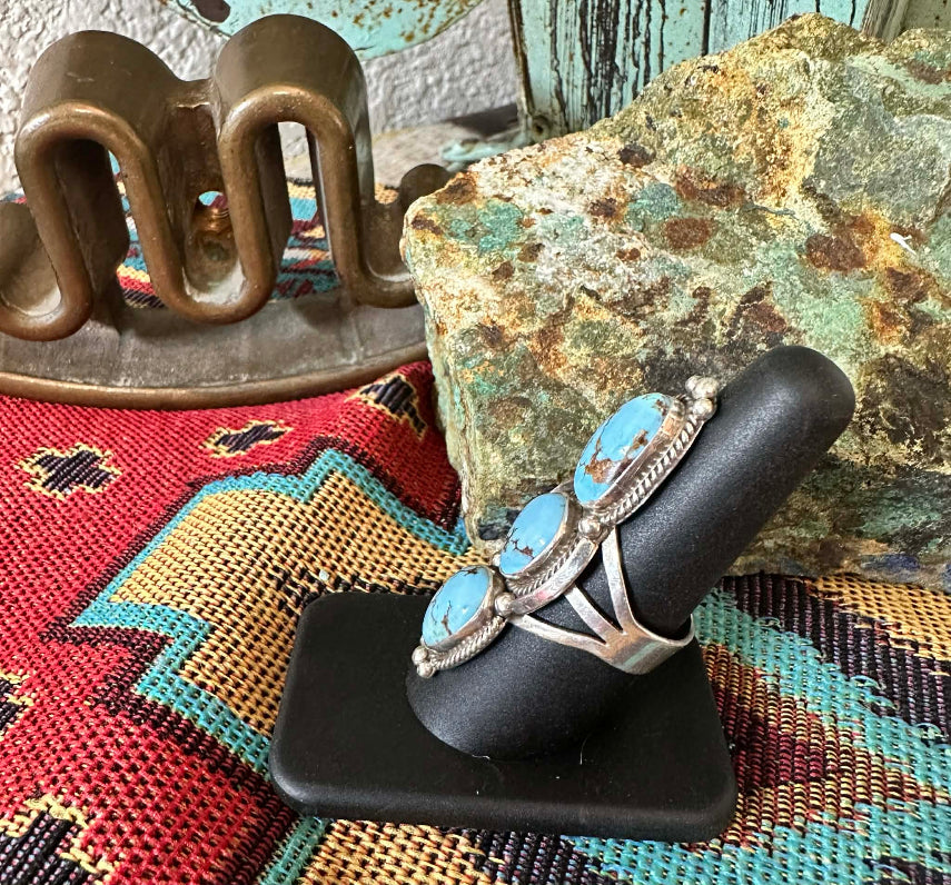 Golden Hills Turquoise Three Stone Ring by Navajo artist E.M. Linkin - side view on ring stand