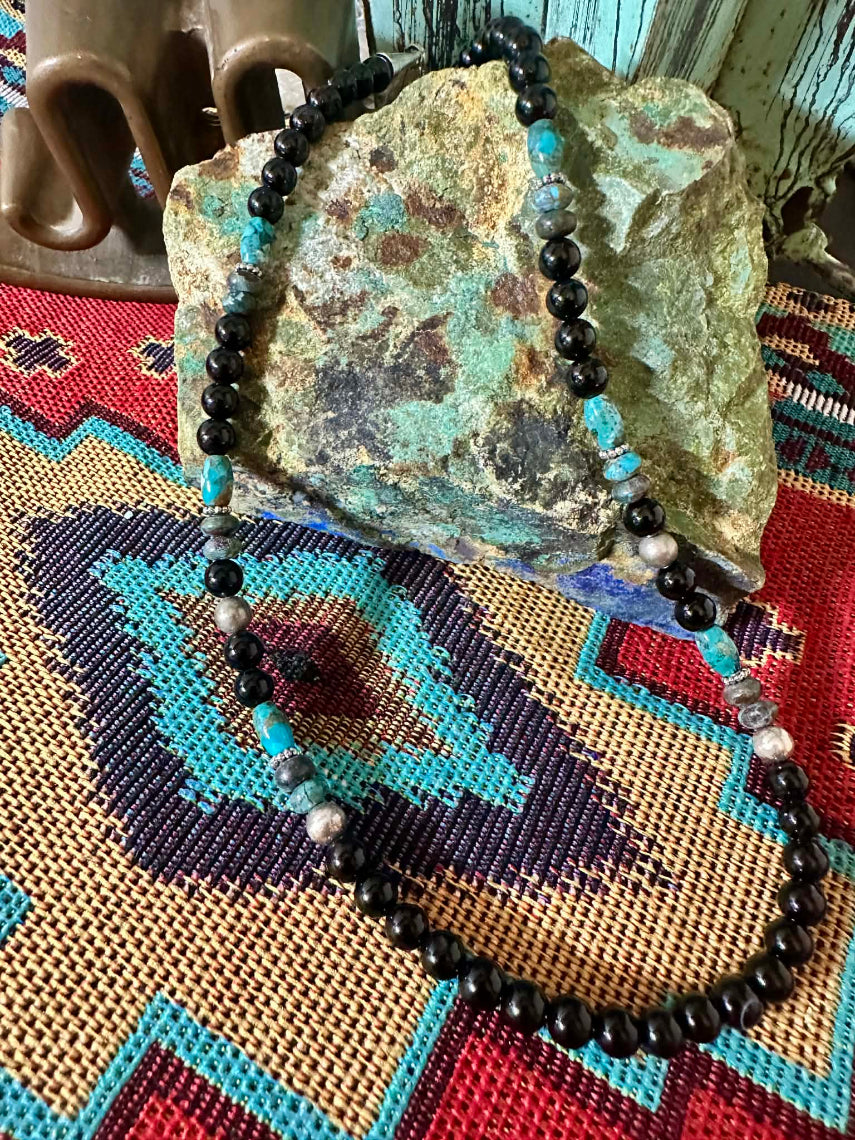 Handmade Sterling Silver, Onyx and Turquoise Beaded Necklace by Rose Singer - draped over turquoise rock